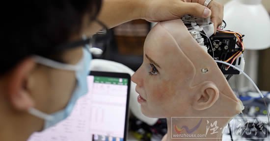 一名工程師調整人形機器人 Grace 的頭部